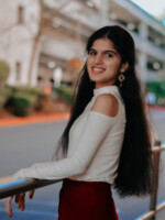 Picture of a teenage girl with dark, long hair in a white and red outfit.